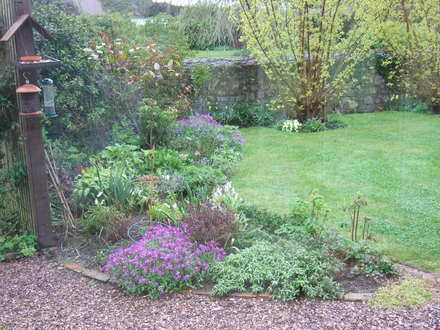 Across the flower bed outside the Garden room window.